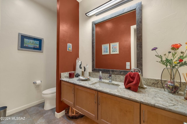 bathroom featuring tile patterned flooring, vanity, and toilet