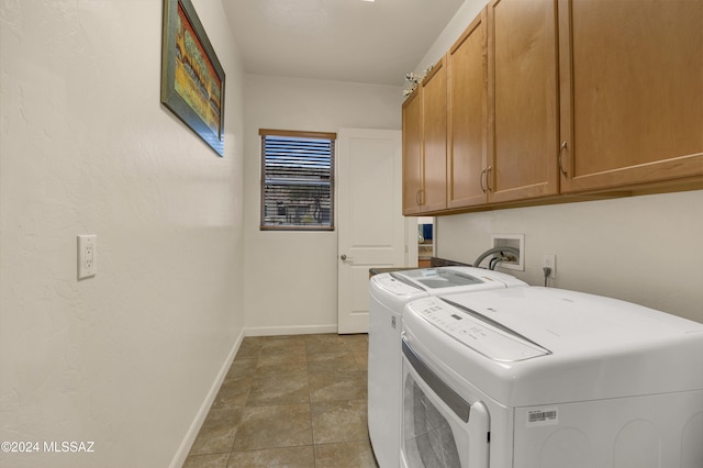 laundry room with cabinets, washing machine and dryer, and tile patterned floors