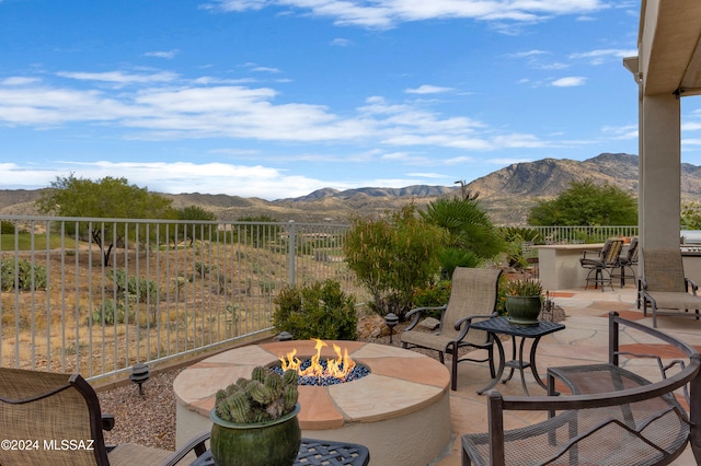 view of patio / terrace featuring a bar, a fire pit, and a mountain view