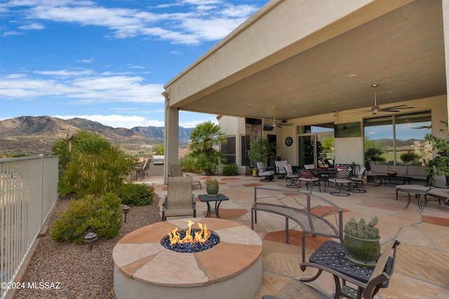 view of patio / terrace with a mountain view, an outdoor fire pit, and ceiling fan