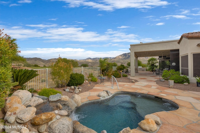 view of pool featuring ceiling fan, a mountain view, and a patio