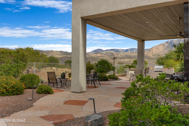 view of patio featuring a mountain view, area for grilling, and ceiling fan