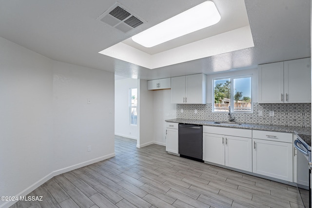 kitchen featuring light hardwood / wood-style floors, dishwasher, sink, backsplash, and white cabinetry