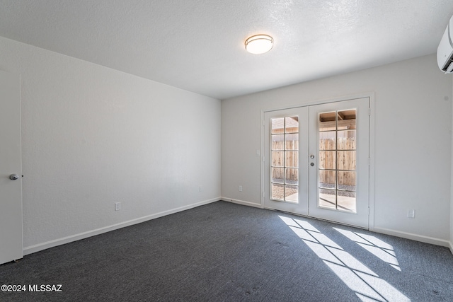 carpeted empty room featuring french doors and a textured ceiling