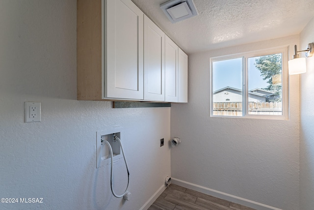 laundry area featuring a textured ceiling, washer hookup, cabinets, and dark hardwood / wood-style floors