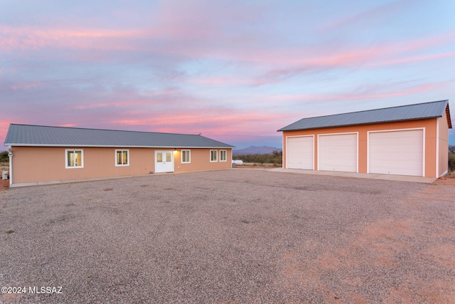 exterior space featuring a garage and an outbuilding