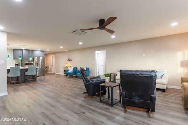 living room featuring light wood-type flooring and ceiling fan