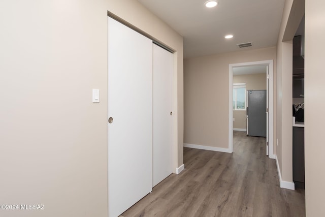 hallway with light hardwood / wood-style floors