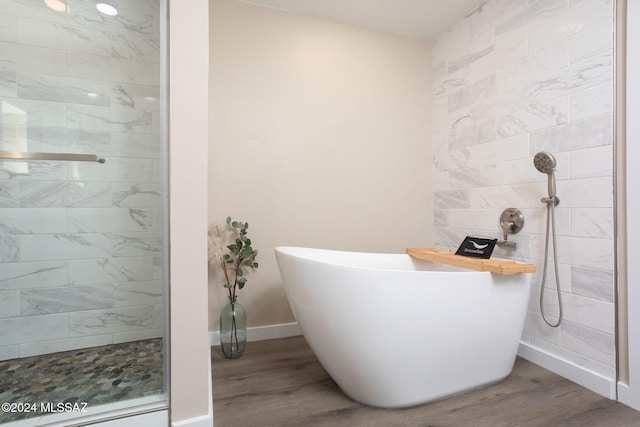 bathroom featuring hardwood / wood-style flooring and plus walk in shower