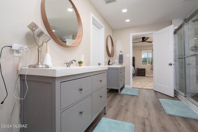 bathroom with a shower with door, vanity, hardwood / wood-style flooring, and ceiling fan