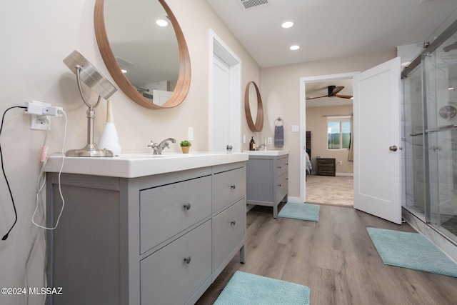 2222 W Stormy Trl, Benson, AZ 85602 - bathroom with two vanities, a ceiling fan, a shower stall, wood finished floors, and recessed lighting