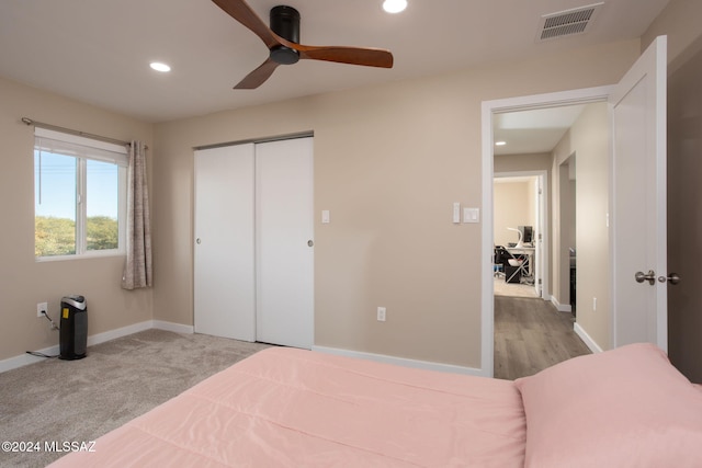 bedroom with light colored carpet, a closet, and ceiling fan
