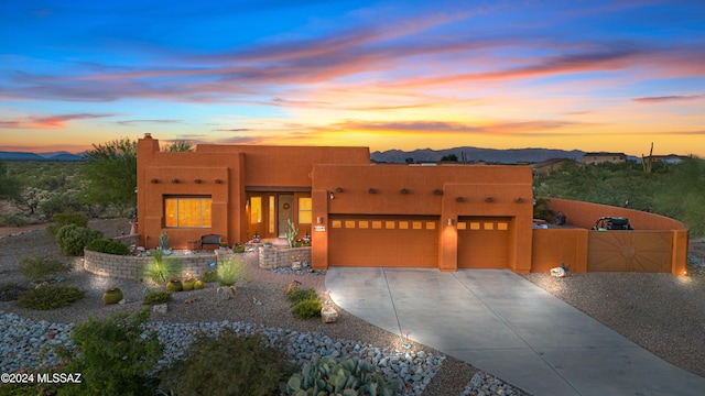 pueblo-style house featuring a mountain view and a garage