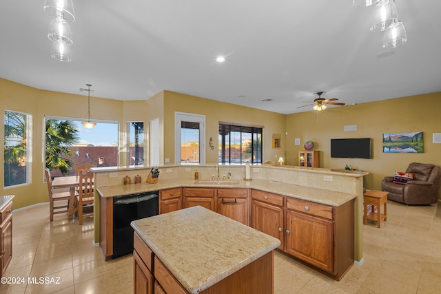 kitchen featuring ceiling fan, dishwasher, sink, pendant lighting, and a spacious island