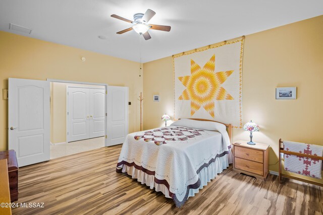 bedroom featuring hardwood / wood-style flooring, ceiling fan, and a closet