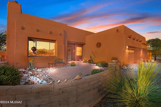 pueblo-style home featuring a garage