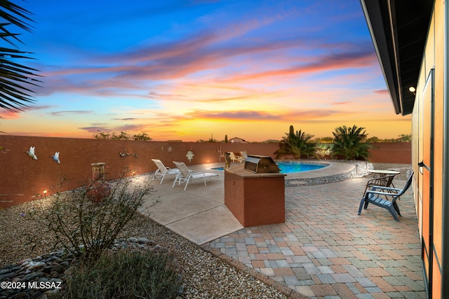 patio terrace at dusk with a fenced in pool