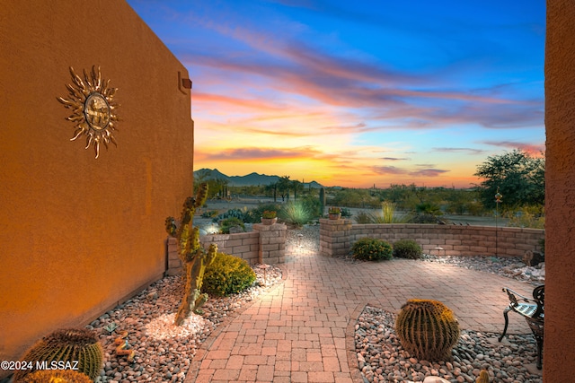 patio terrace at dusk featuring a mountain view