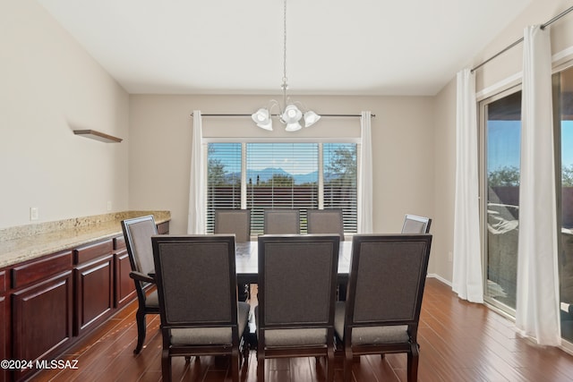 dining room with dark hardwood / wood-style floors and a notable chandelier