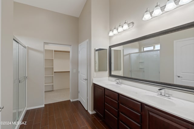 bathroom featuring hardwood / wood-style floors, vanity, high vaulted ceiling, and a shower with door