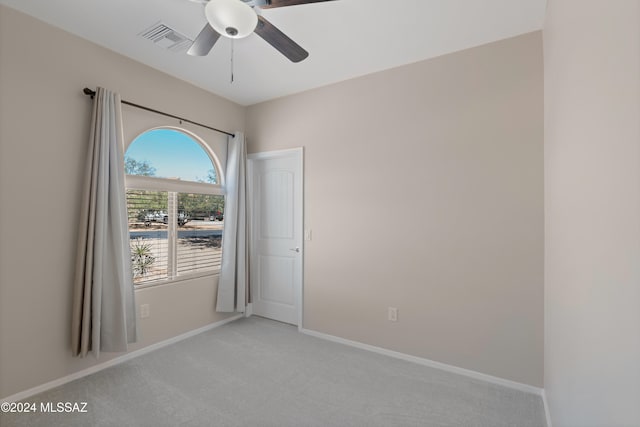 spare room featuring light colored carpet and ceiling fan