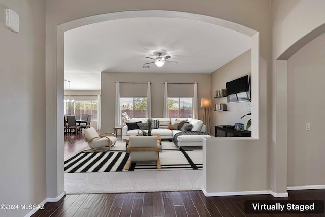 living room featuring ceiling fan and dark hardwood / wood-style floors