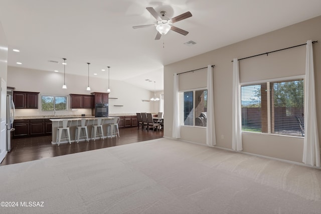 living room featuring vaulted ceiling, dark hardwood / wood-style floors, and ceiling fan with notable chandelier