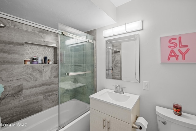 full bathroom with enclosed tub / shower combo, vanity, and toilet