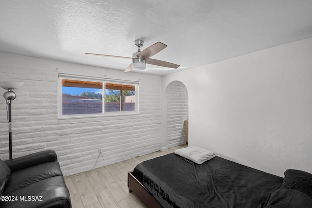 bedroom featuring a textured ceiling, light hardwood / wood-style floors, and ceiling fan