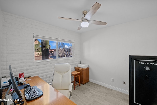 office area featuring light wood-type flooring, brick wall, and ceiling fan