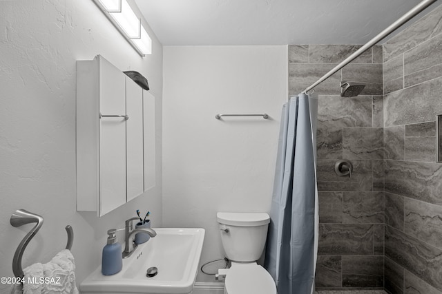 bathroom featuring toilet, sink, and a shower with shower curtain