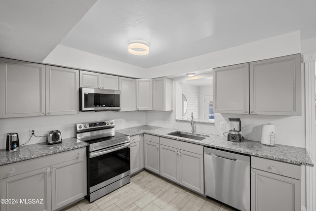 kitchen featuring gray cabinets, appliances with stainless steel finishes, and sink