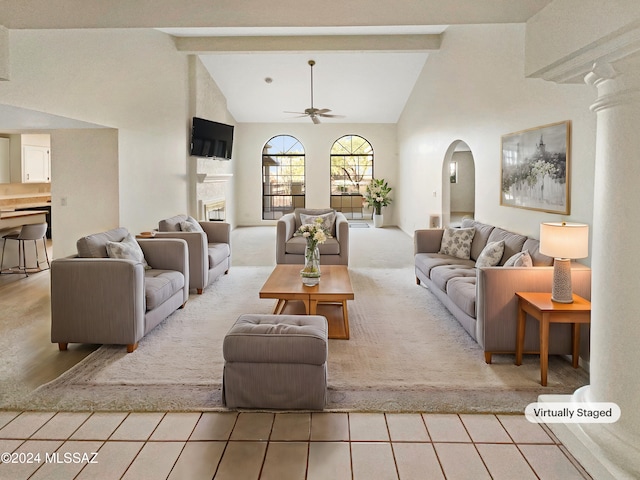 tiled living room with high vaulted ceiling, beamed ceiling, ceiling fan, and decorative columns