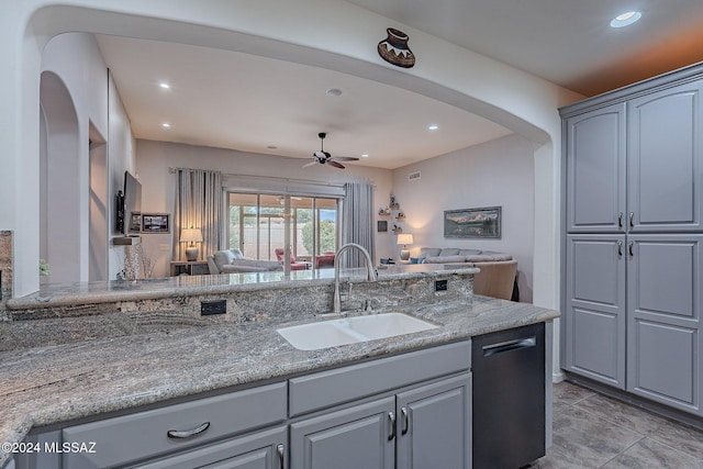 kitchen with gray cabinetry, ceiling fan, dishwasher, sink, and light stone counters