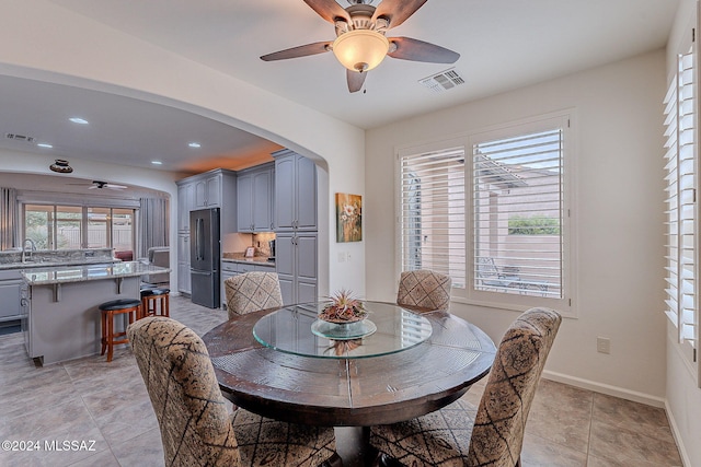 dining room with ceiling fan, light tile patterned flooring, sink, and a wealth of natural light