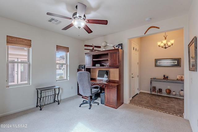 carpeted office space featuring ceiling fan with notable chandelier