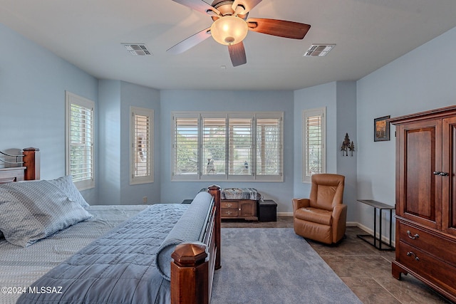 tiled bedroom featuring multiple windows and ceiling fan