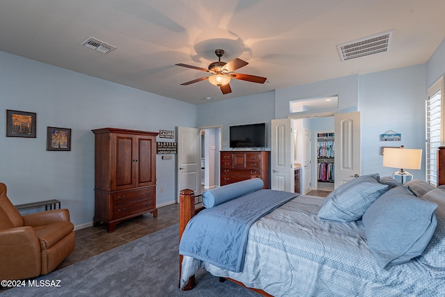 bedroom featuring dark tile patterned flooring, ceiling fan, and connected bathroom