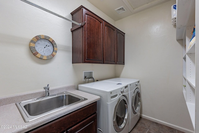 clothes washing area featuring cabinets, washing machine and clothes dryer, and sink