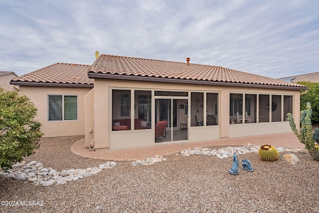 back of property with a sunroom