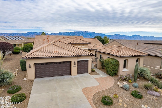 mediterranean / spanish-style home with a mountain view and a garage