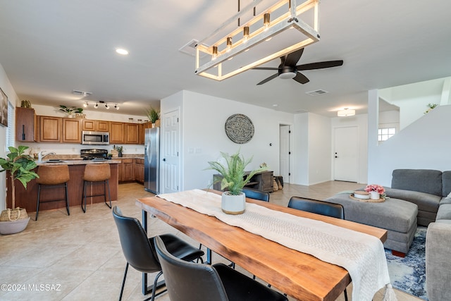 dining space with ceiling fan, light tile patterned floors, and sink