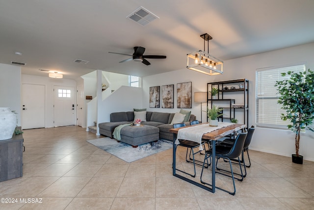 dining area featuring ceiling fan with notable chandelier, a healthy amount of sunlight, and light tile patterned flooring