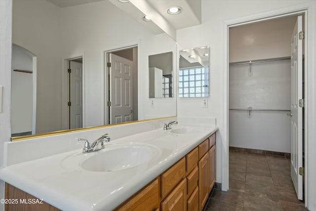 full bath with double vanity, baseboards, a sink, and tile patterned floors