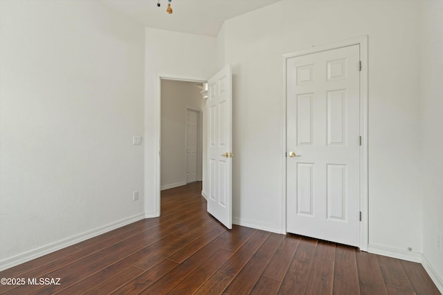 unfurnished bedroom featuring dark wood-style floors and baseboards