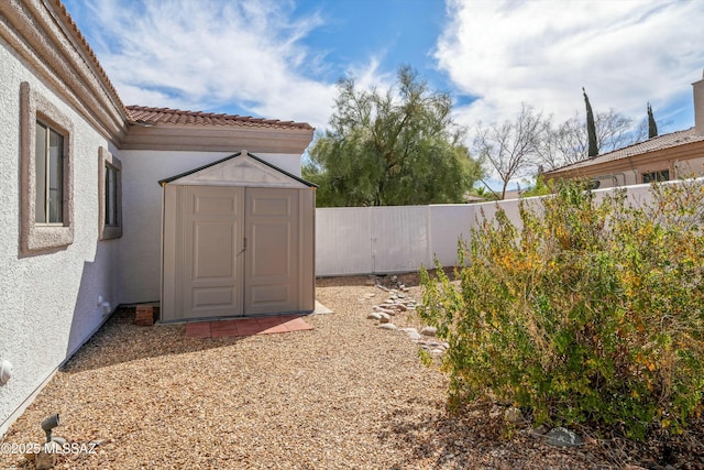 view of yard featuring an outbuilding, a fenced backyard, and a storage shed