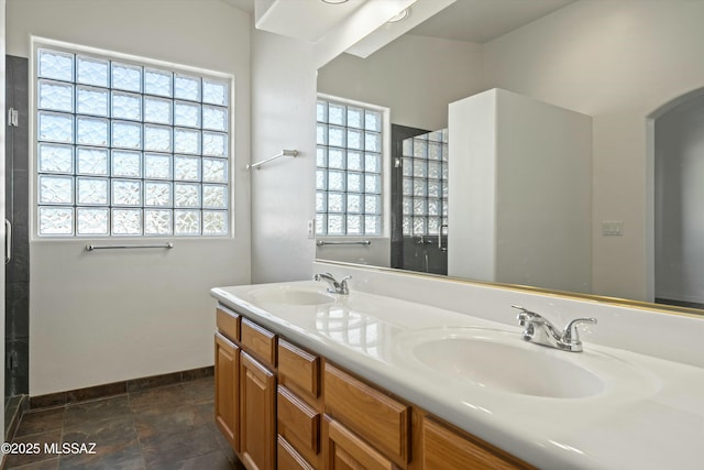 full bathroom with a sink, baseboards, and double vanity