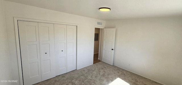 unfurnished bedroom with carpet flooring and a closet