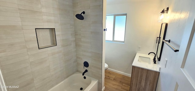 full bathroom featuring toilet, tiled shower / bath, hardwood / wood-style flooring, and vanity