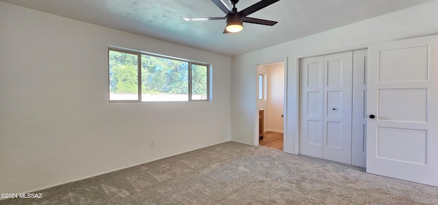 unfurnished bedroom with a closet, ceiling fan, vaulted ceiling, and light colored carpet